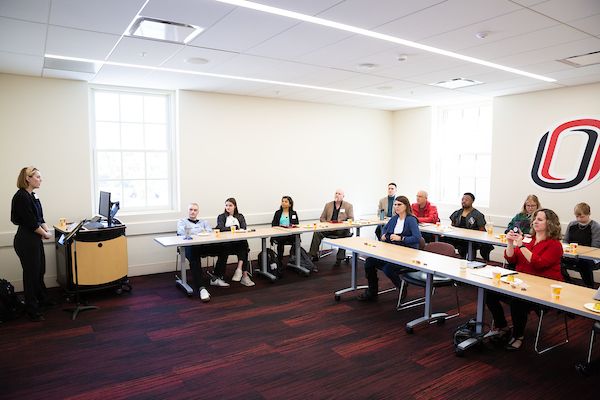 judges sit at tables at uno's research and creative activity fair