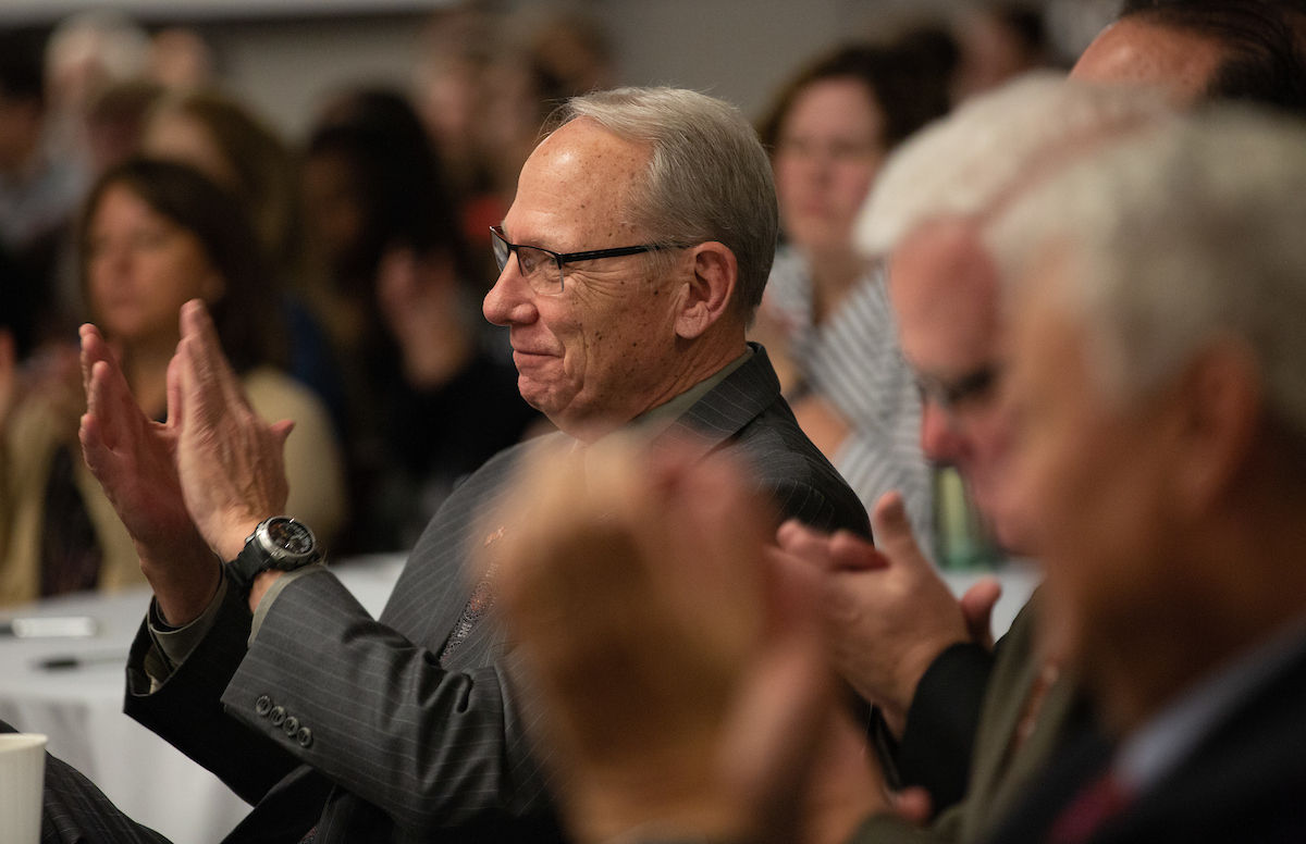 John E. Christensen applauds a speaker
