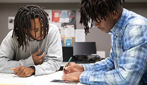 Two male students looking at a document