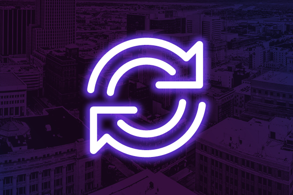 Neon circular arrows icon on a purple city background.