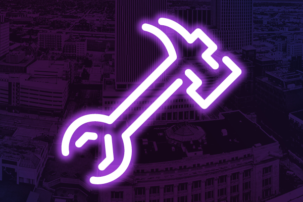 Neon wrench icon on a purple city background