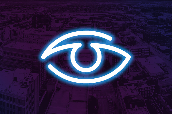 Neon eye icon on a purple city background.