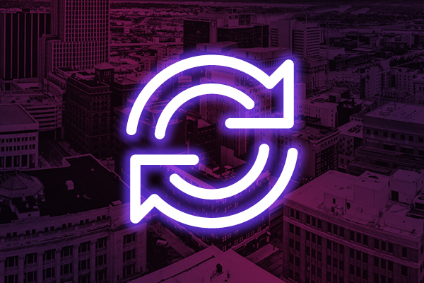 Neon circular arrows icon on a purple city background.