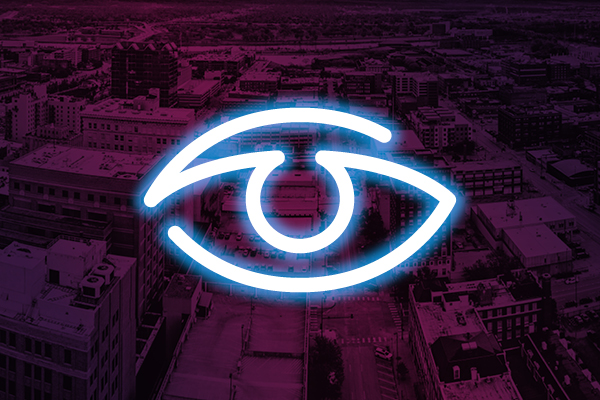 Neon eye icon on a purple city background.