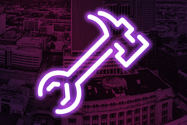 Neon wrench icon on a purple city background