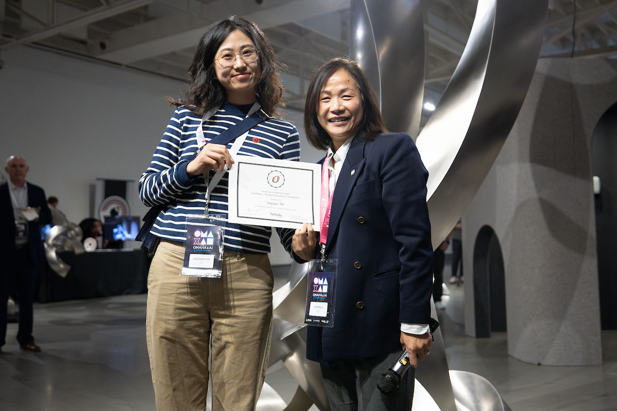 chacnellor li standing with a woman holding a certificate.