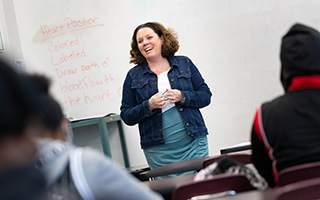 teacher standing in front of blackboard