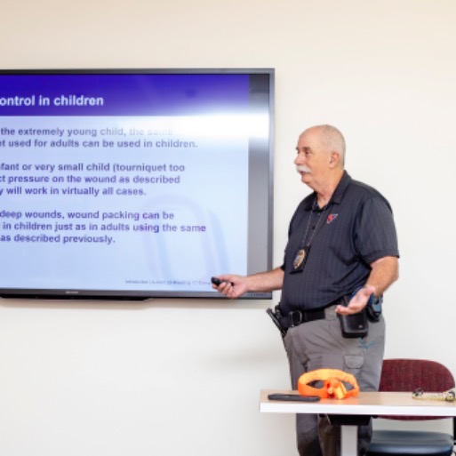 Man standing in front of a classroom screen teaching an active shooter training class