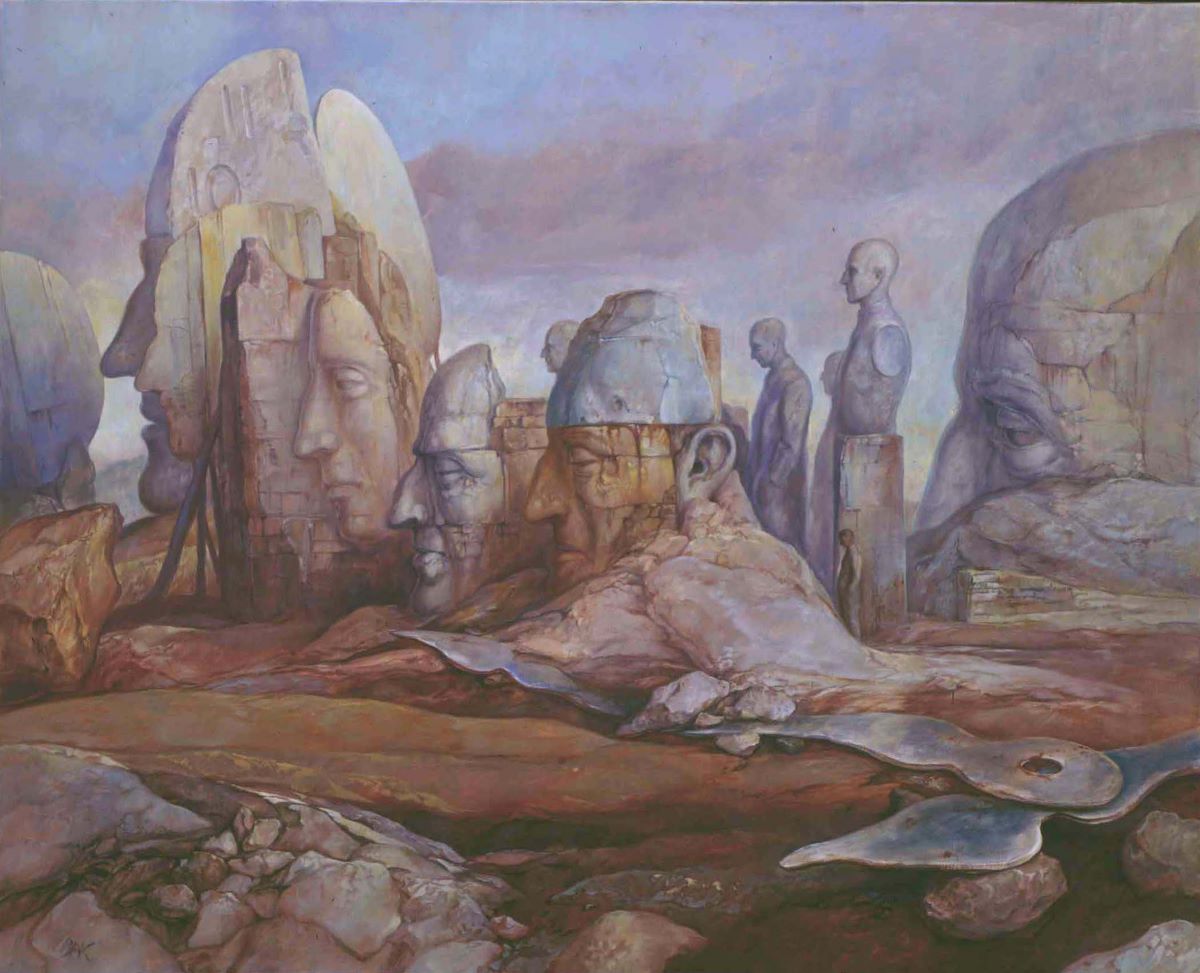A man stands in a barren landscape surrounded by giant stone heads in various stages of decay. The oversized hands of a clock lie discarded in the foreground.