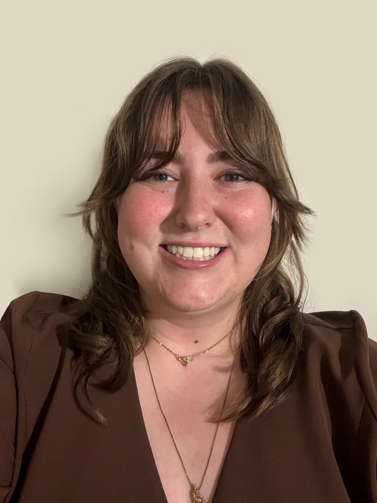 A profile picture of Clarissa in a brown shirt smiling at the camera.