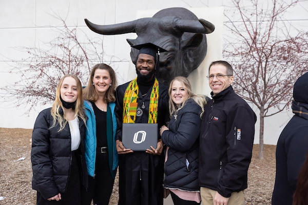 graduate posing with diploma