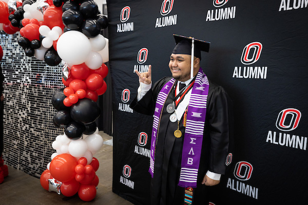 graduate taking picture in cap and gown