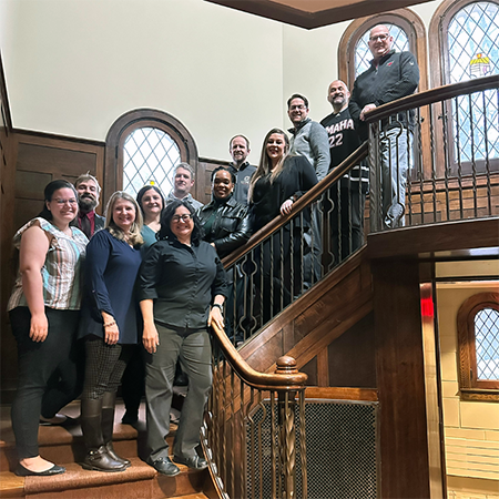 member of student life and well being pose for a picture on the hayden house staircase