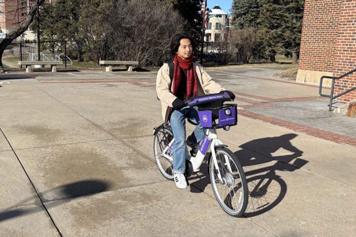 Photo from The Gateway of a student riding an e-bike on campus.