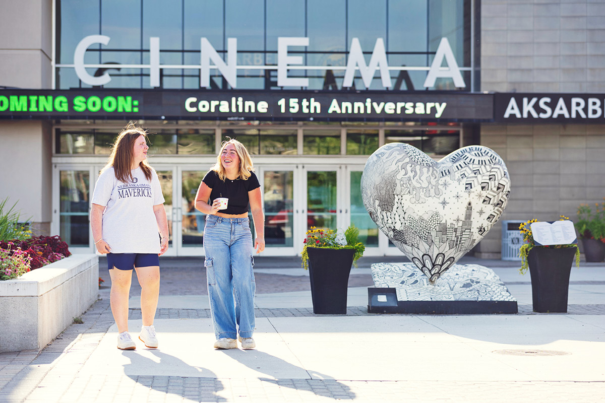 Two students walk together outside the Aksarben Village cinema.