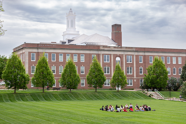 UNO students sit in a circle in the pep bowl. 