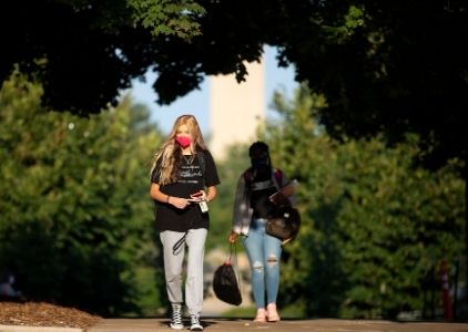 UNO students walk on campus wearing masks.