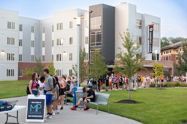 students stand in line on scott campus waiting to enjoy movie night