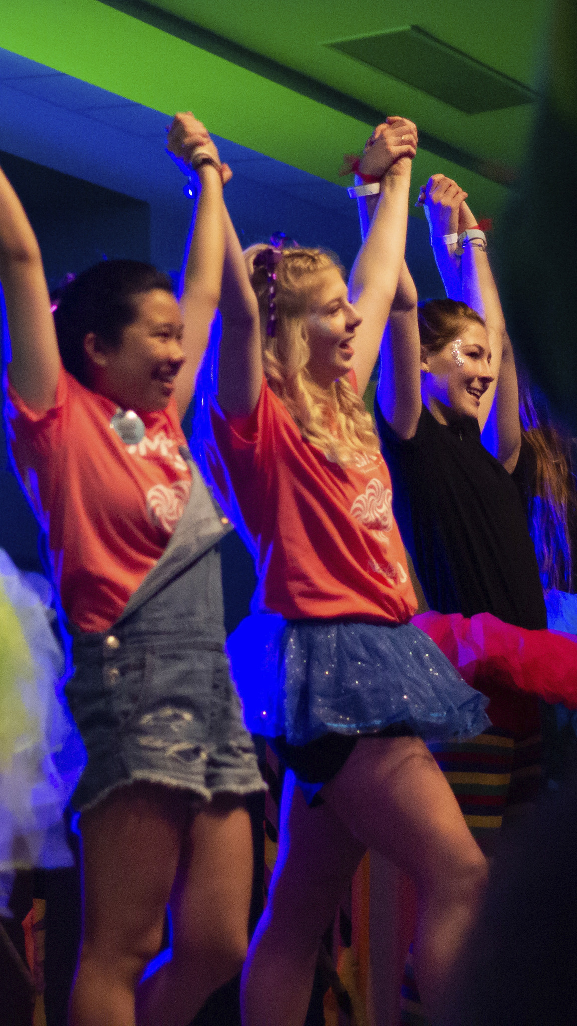 three students on stage at OMAthon