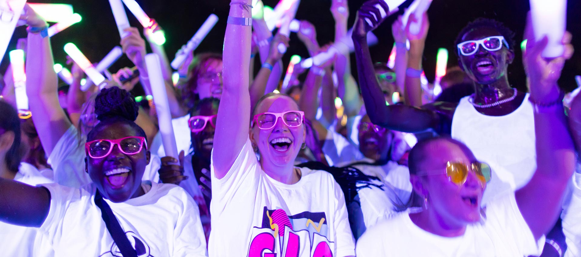 students with arms up at glo concert