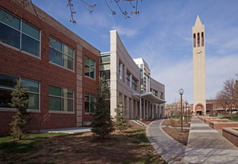 Image shows the College of Public Administration and Community Service with the Bell Tower in the background.