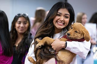 Student holding a puppy