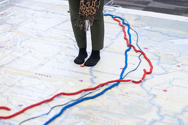 a pair of sock-clad feet stands on a huge map of the midwest