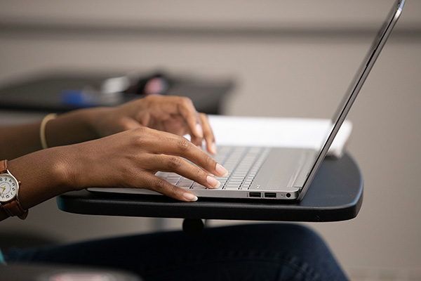hands typing on a laptop