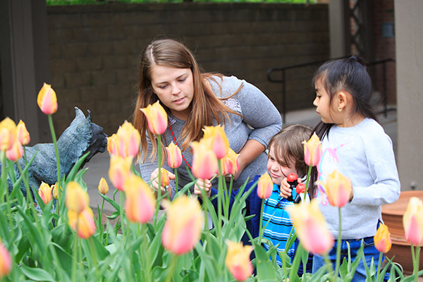 a woman looks at flowers with a young child