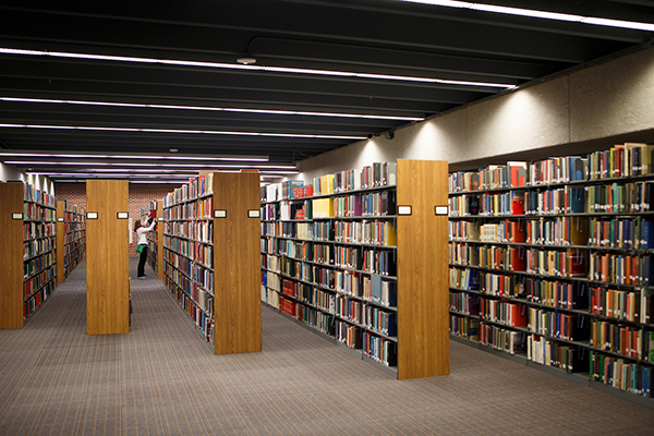 a woman looks at a book in the rare books archive at uno