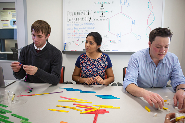 a group of students sits at a table working on a project