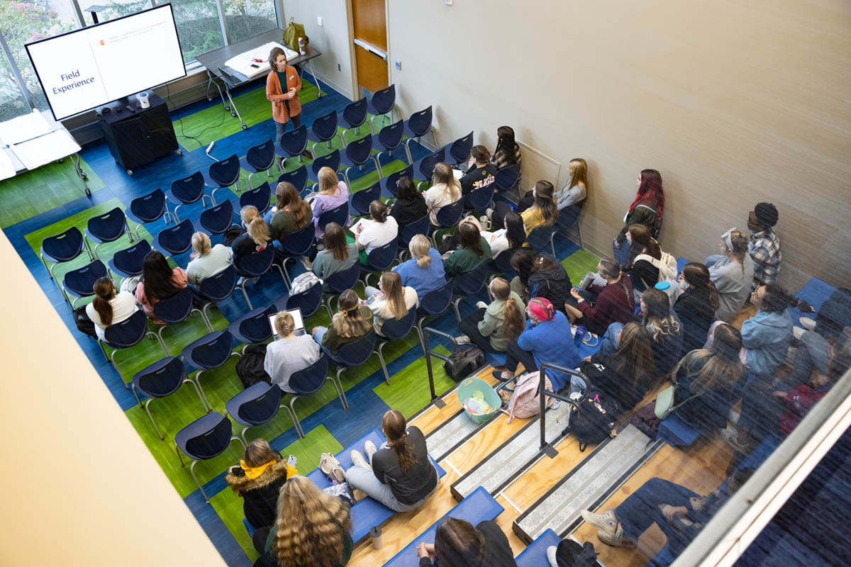 An educator teaches a class in a bright and airy classroom