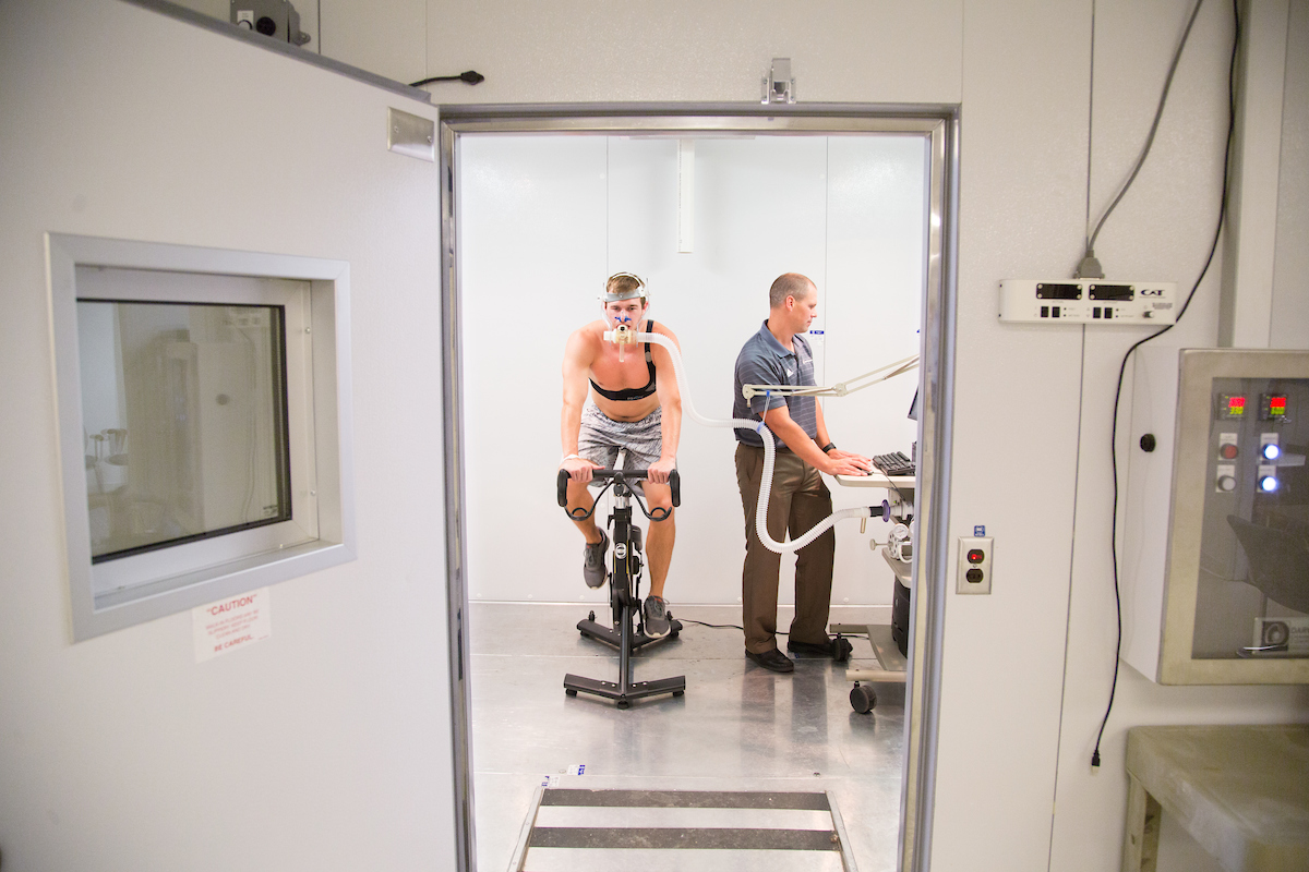 subject on stationary bike inside environmental chamber