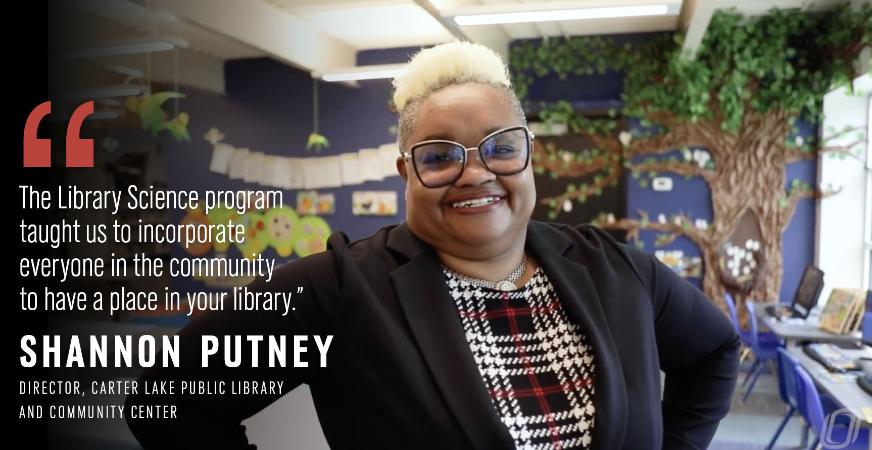 A librarian poses for a photo in front of her library space