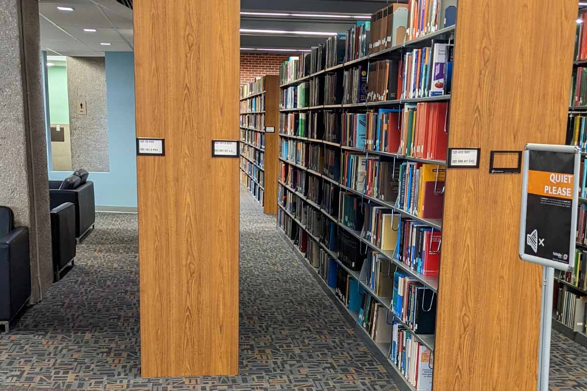 the end of a library shelving unit with the call number ranges listed
