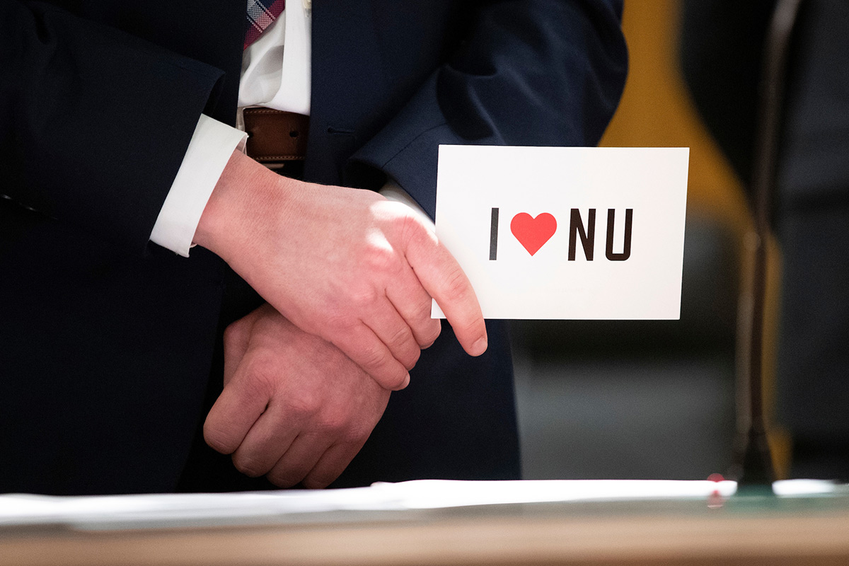Event attendee holds "I Love NU" notecard.