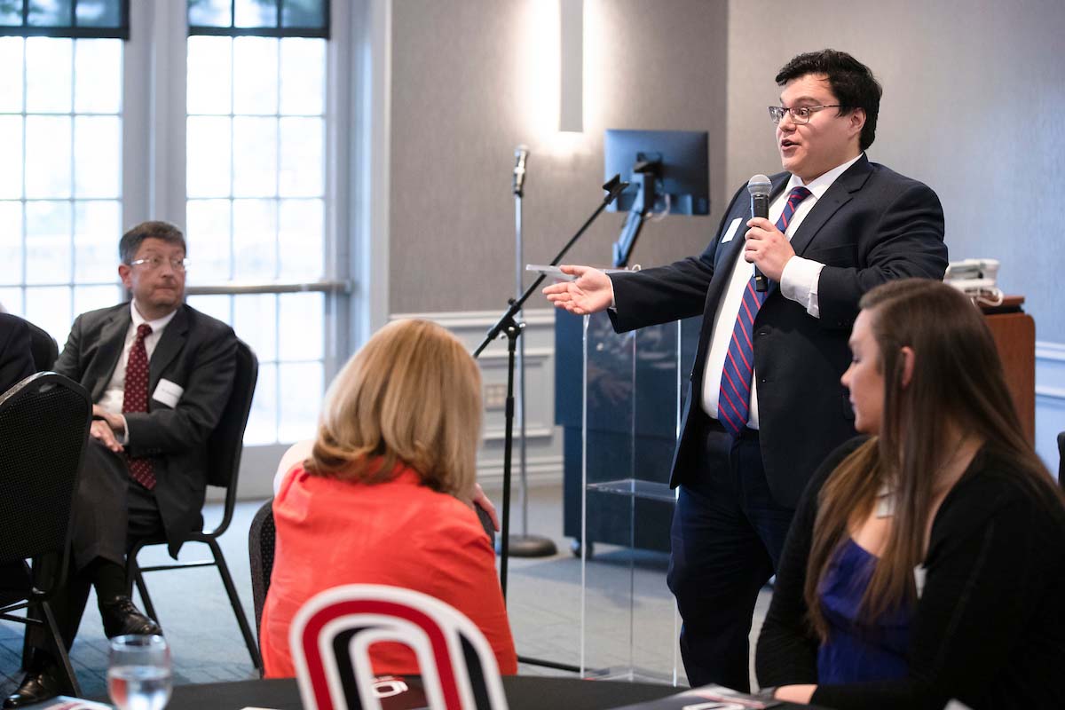 Jonathan Acosta, president of the Academic Advising Council, speaks with a microphone to a crowd of UNO employees
