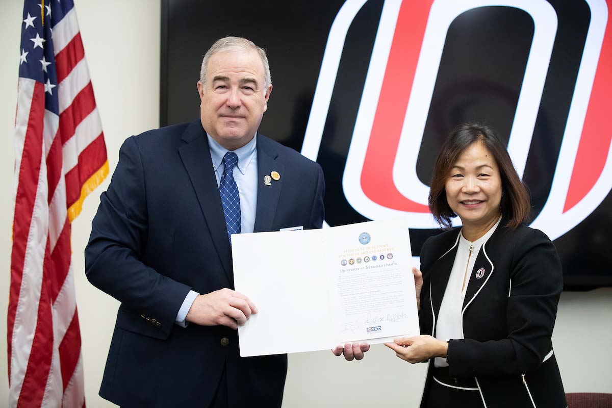 Chancellor Joanne Li, Ph.D., CFA, and Maj. Gen. (Ret.) Rick Evans, executive director of the National Strategic Research Institute and state chair of the Nebraska ESGR committee, hold up the Statement of Support for the U.S. Department of Defense's Employer Support of the Guard of Reserve (ESGR) signed by UNO at a ceremony held on Friday.