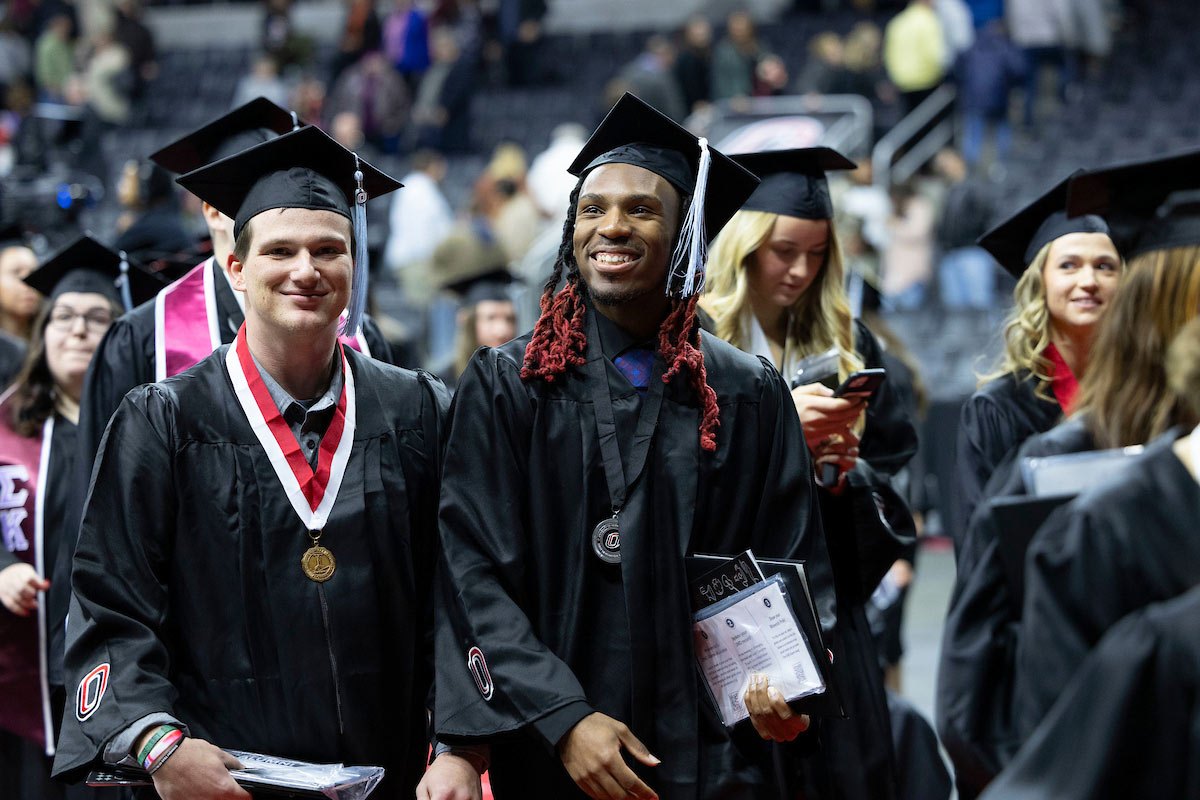 students smile while walking out of the arena following the ceremony
